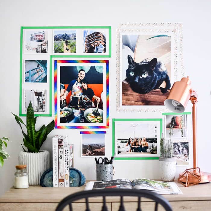 Posters hung on a white wall using colorful washi tape at the corners