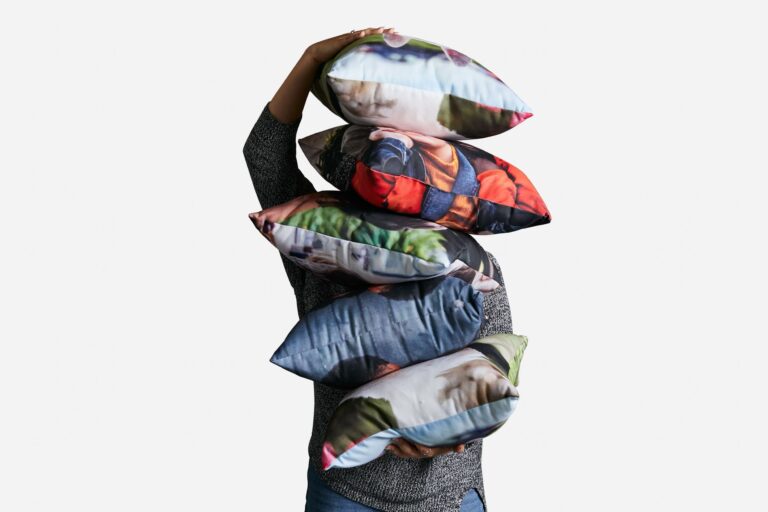 A man holding a stack of cushions