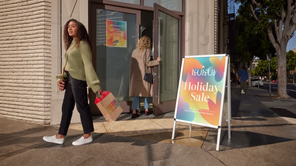 A-frame sign on a sidewalk promoting a retail Holiday Sale for Kukui brand.