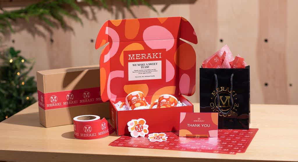Corporate holiday gifts with branded packaging and custom stickers.
