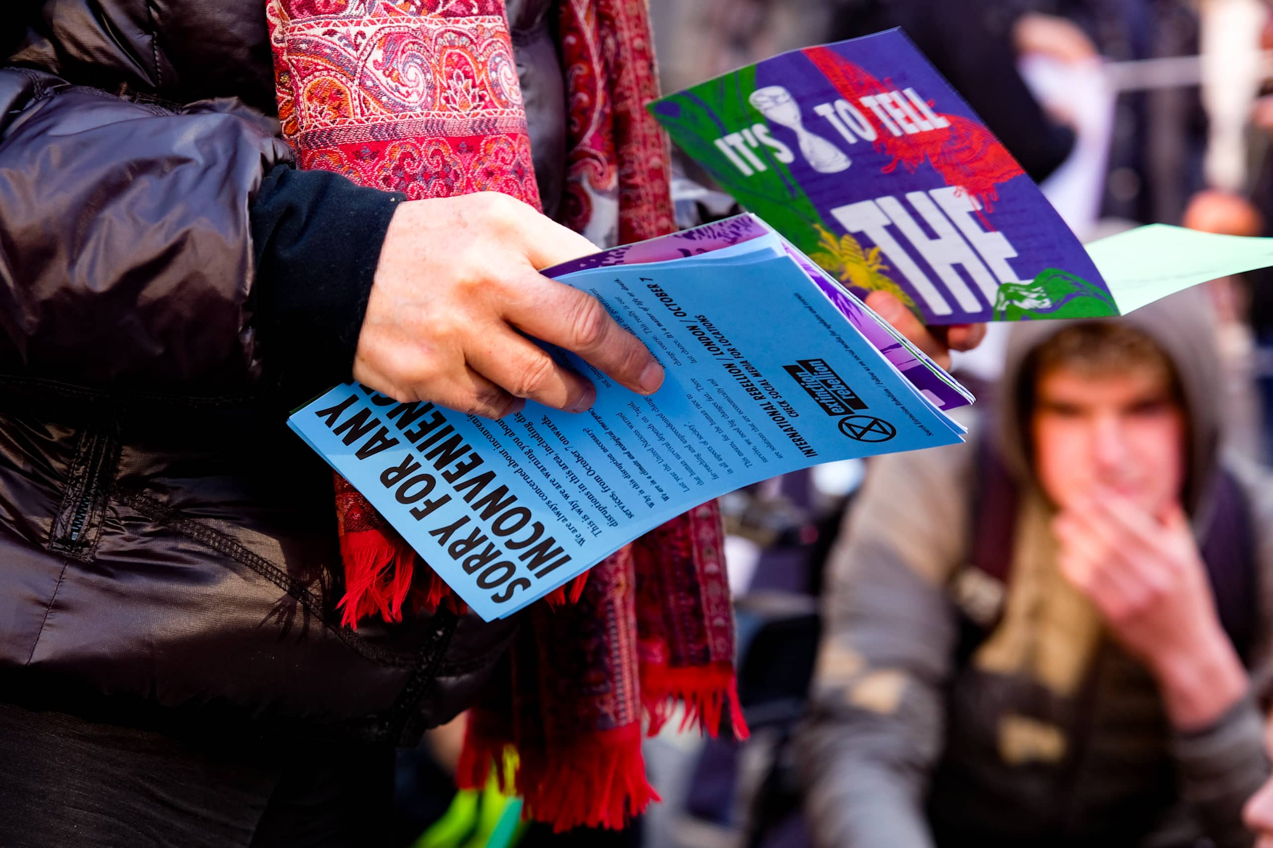 Mid-shot of a person holding an assortment of colourful flyers.
