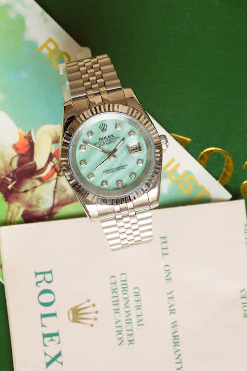 A Rolex watch next to a Rolex brochure